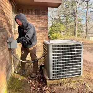 HVAC technician performing air conditioning maintenance