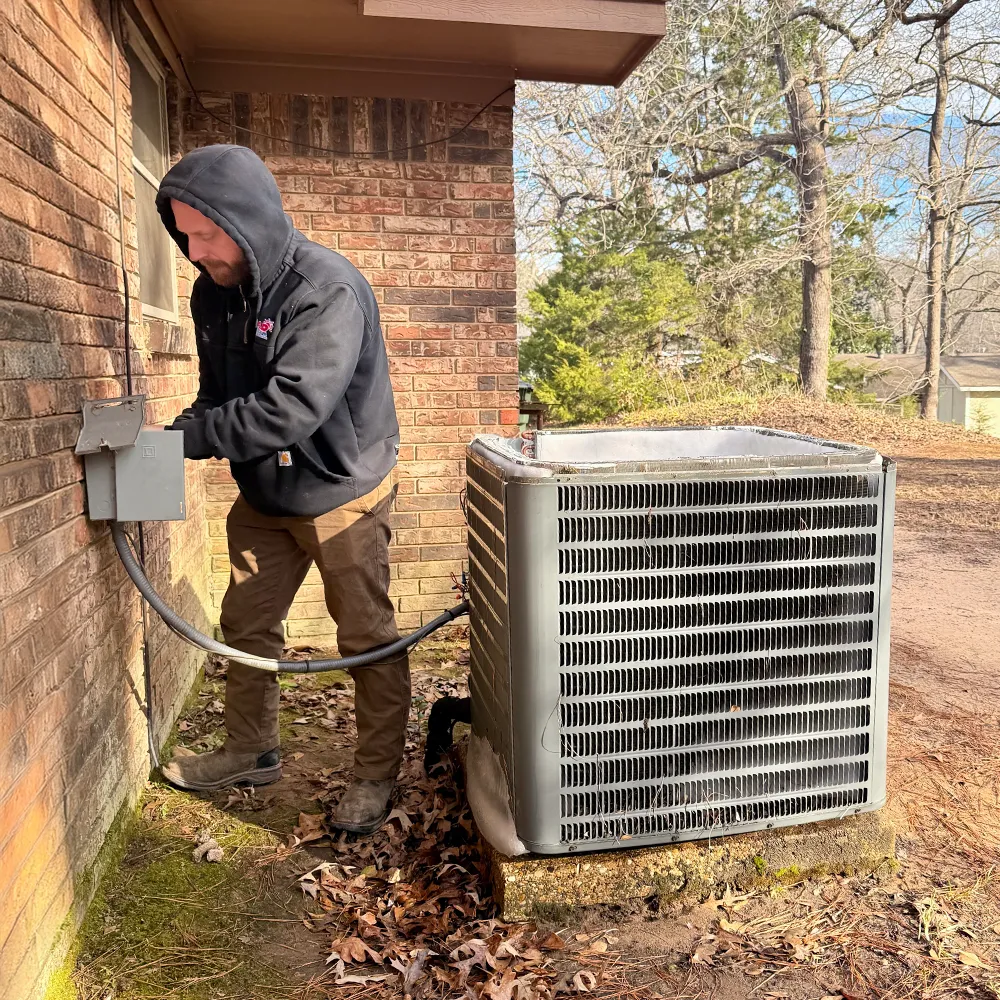 HVAC technician performing air conditioning maintenance