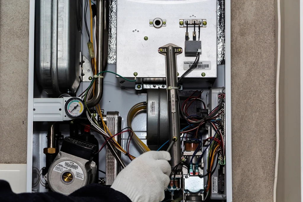 Technician inspecting internal furnace components during limit switch diagnostics
