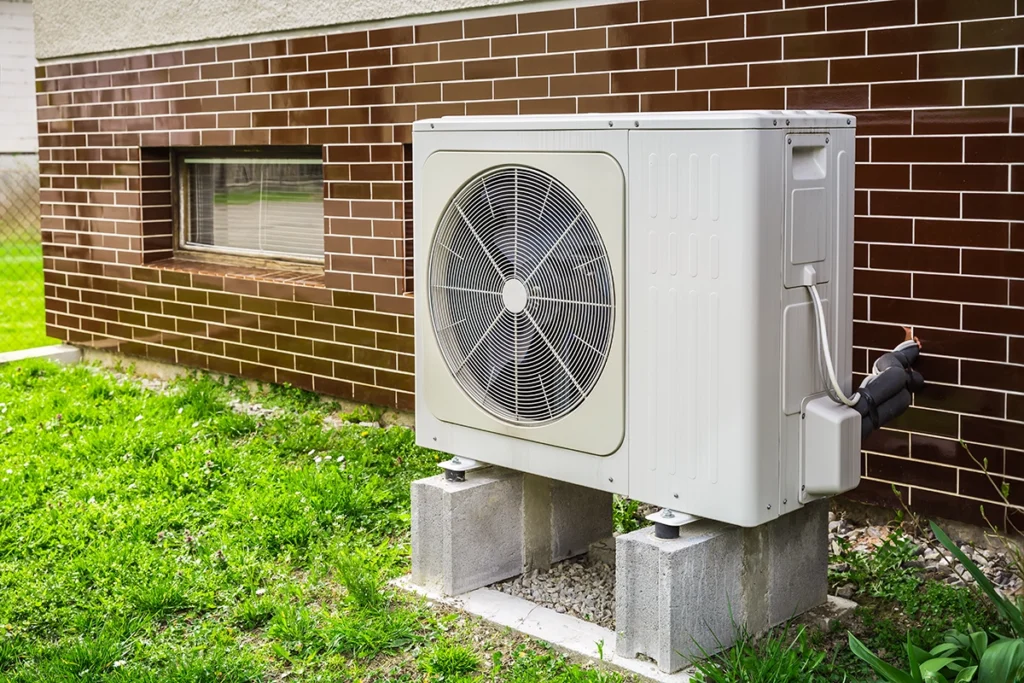 Outdoor condenser for a 2 zone mini split system installed beside a home for efficient ductless heating and cooling
