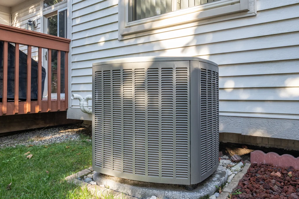 Outdoor HVAC unit beside a home, showing why BTU meaning matters when choosing properly sized heating and cooling equipment.
