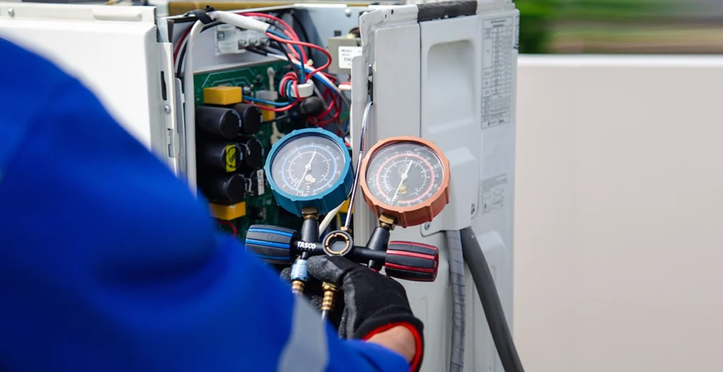 HVAC technician checking system gauges during R410A refrigerant service