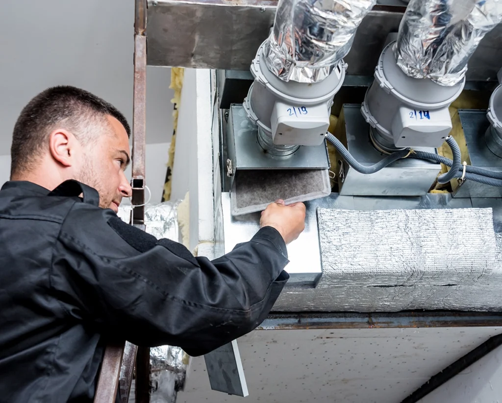 HVAC technician checking ductwork filter for whole-home air purifiers