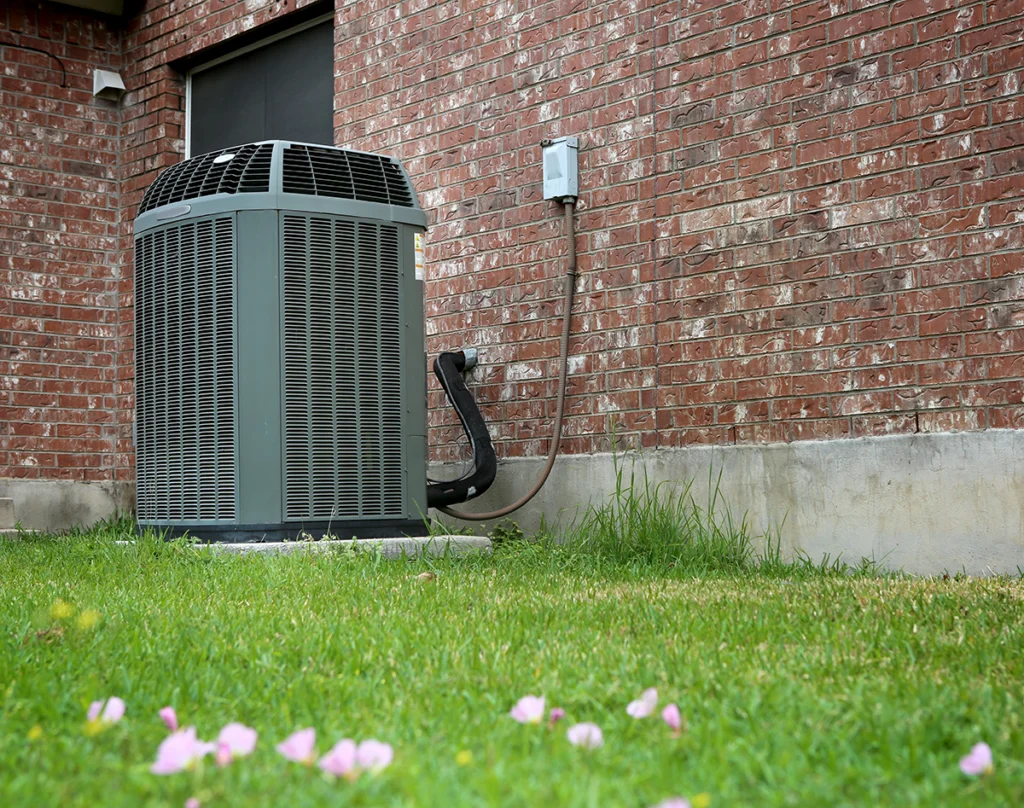 Outdoor heat pump in Chapel Hill TX installed beside a brick home.
