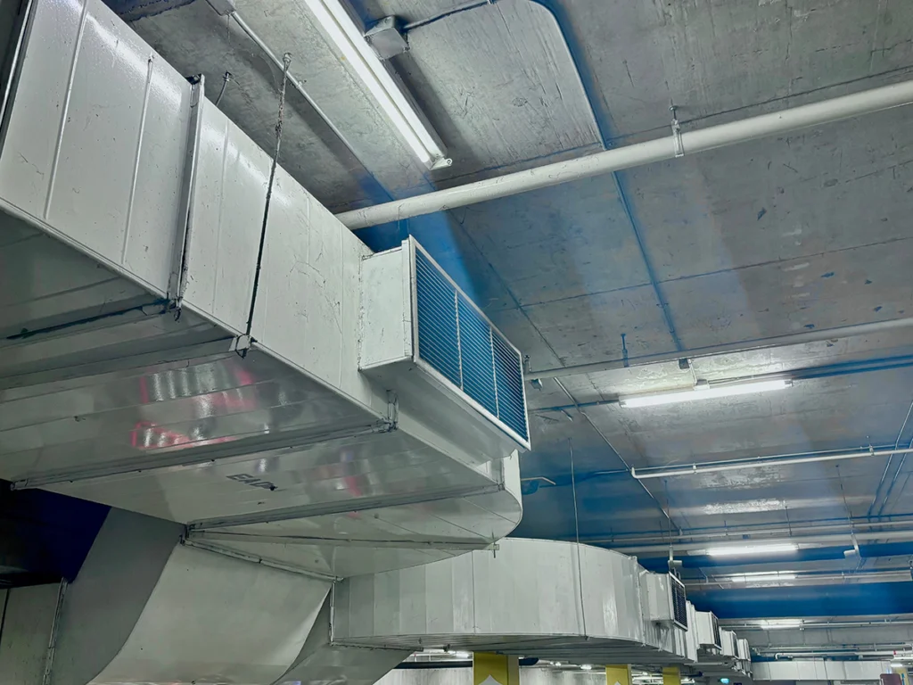 Plenum HVAC ductwork with large metal air distribution sections connected overhead