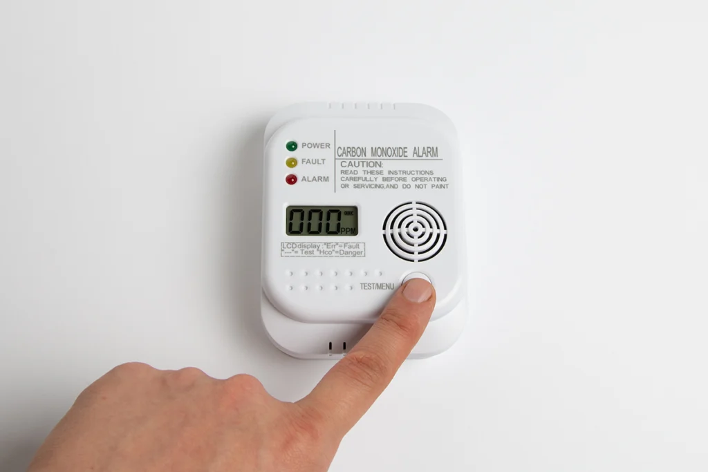 Furnace heat exchanger cracked causing carbon monoxide concerns in Rusk, TX: hand pressing the test button on a wall-mounted
