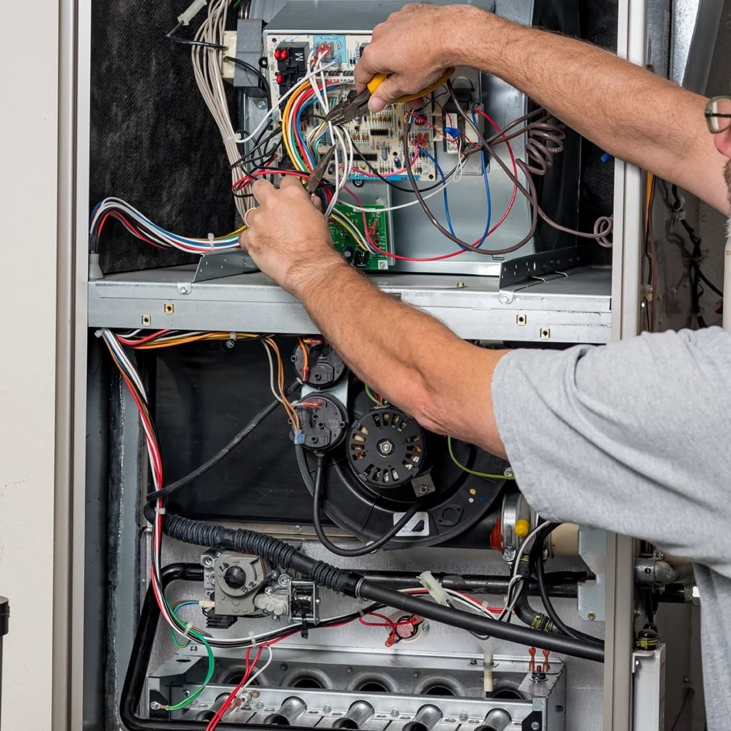 Furnace ignition sensor not detecting flame in Frankston TX: technician repairing wiring and electrical components