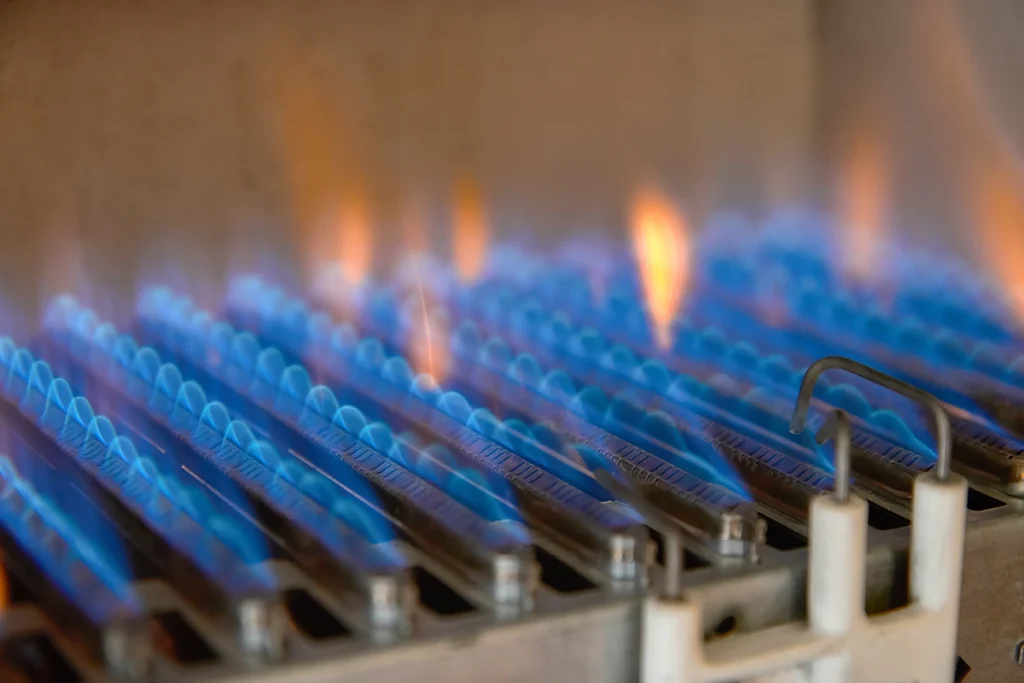 Furnace ignition system not lighting in Arp, shown by blue burner flames inside a gas furnace